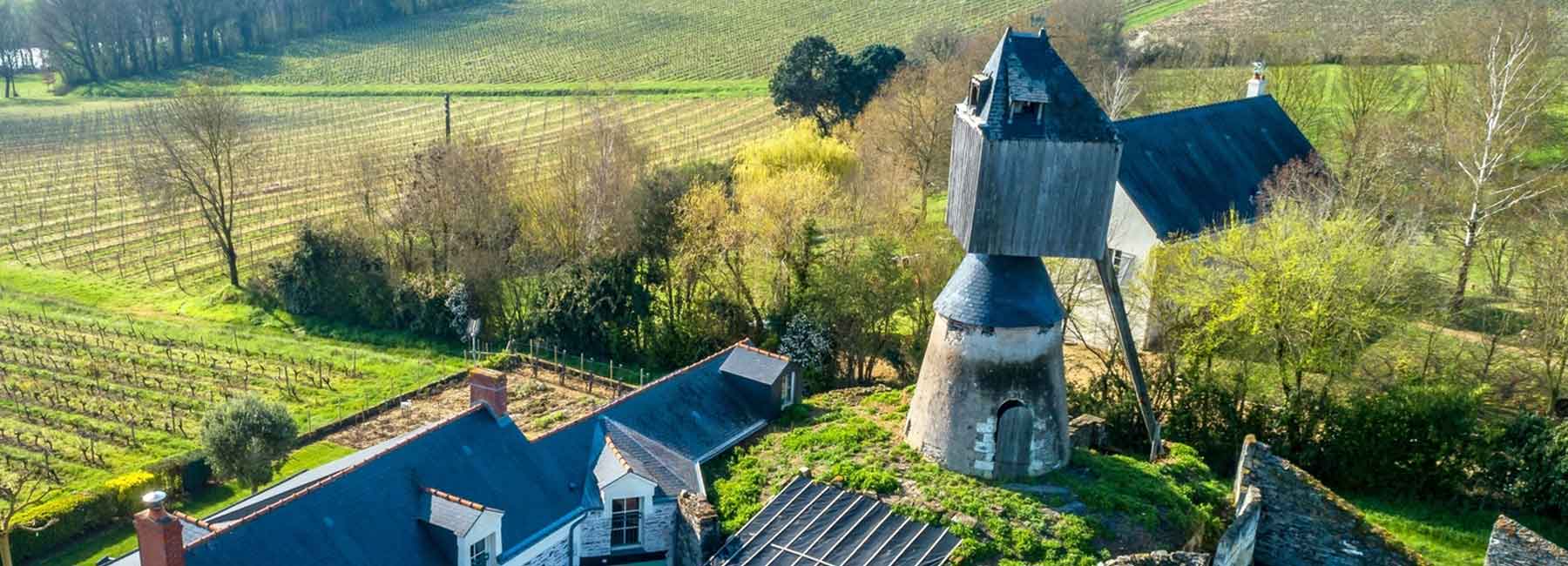 un moulin sans ailes vu du ciel avec quelques maisons de village