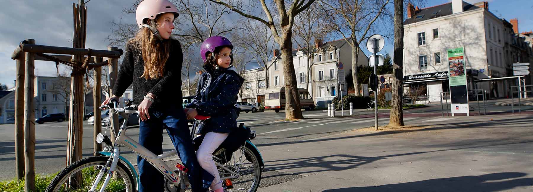 Deux adolescentes sur un vélo en centre-ville