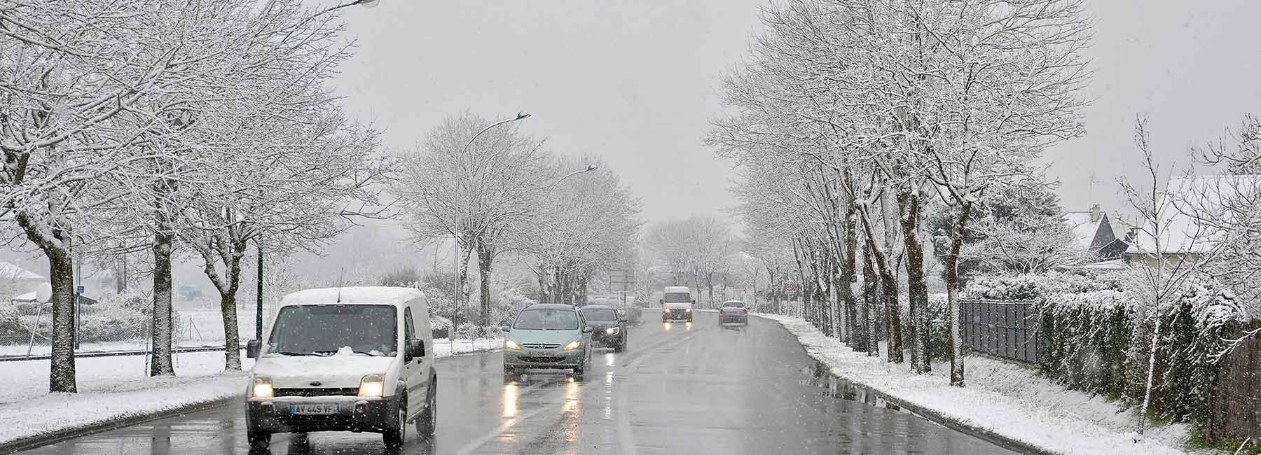 Véhicules sur une route enneigée