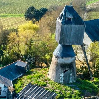 un moulin sans ailes vu du ciel avec quelques maisons de village