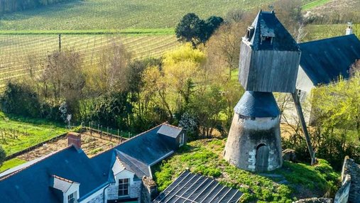 un moulin sans ailes vu du ciel avec quelques maisons de village