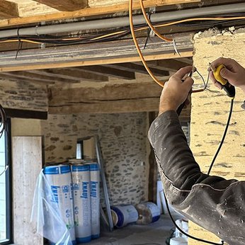 Ouvrier effectuant des travaux d'électricité dans une maison