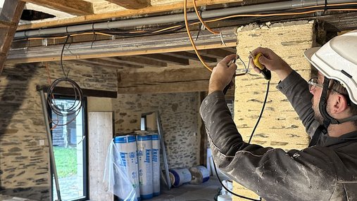 Ouvrier effectuant des travaux d'électricité dans une maison